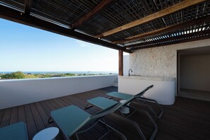 An outdoor patio with a view of the sea, a stone wall, and a wooden ceiling. - ESPACIO EBANO (Santa Maria Colotepec)