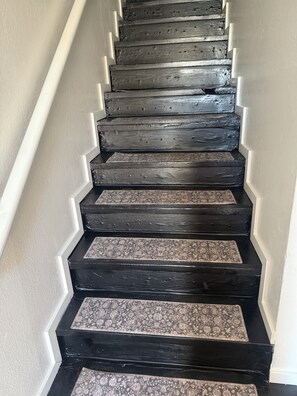 A staircase with black steps and white walls. - Delightful 3-bedroom townhome with AC in Mesa (Mesa)