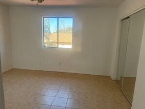 A room with a large window, a sliding door, and a tiled floor. - Delightful 3-bedroom townhome with AC in Mesa (Mesa)