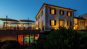 Un edificio di due piani con un balcone e una zona salotto all'aperto.