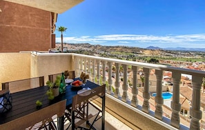 A balcony with a table set for two, overlooking a scenic view of a town and mountains. - 2 bedroom awesome apartment in Rojales (Rojales)