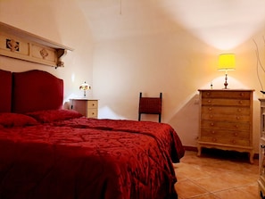 A bedroom with a large bed, a dresser, a chair, and a lamp. - Casa Mapi: an oasis of peace in Garbatella, just 3 metro stops from the Colosseum (Roma)