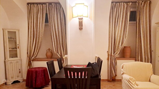 A dining area with a table, chairs, and a lamp. There is a cabinet and a vase on the windowsill. - Casa Mapi: an oasis of peace in Garbatella, just 3 metro stops from the Colosseum (Roma)