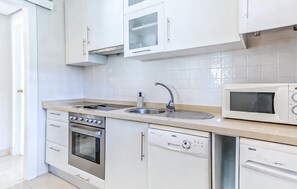 A modern kitchen with white cabinets, a stainless steel oven, a dishwasher, and a microwave. - Beautiful apartment in San Javier with WiFi (San Javier)