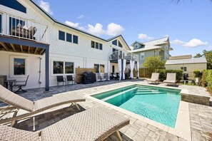 A residential property with a swimming pool, outdoor seating, and a covered patio area. - Remodeled & modern coastal escape duplex with pool, close to beach (Fernandina Beach)
