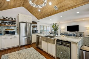 Eine moderne Küche mit Edelstahl-Kühlschrank, Backofen und Geschirrspüler.