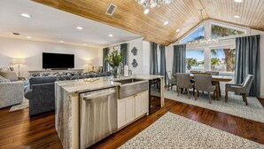 Un espacio habitable moderno con isla de cocina, comedor y zona de estar.