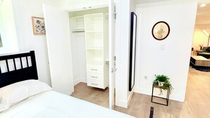 Un dormitorio con una cama, un armario y un espejo.