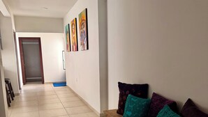 A hallway with a wooden bench, a blue mat, and a door leading to a room. - Adorable 2-bedroom apartment in lovely Jalostotitlán perfect for relaxing (Jalostotitlán)