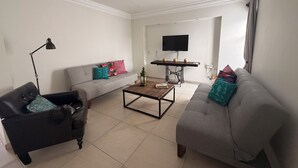 A living room with a sofa, a coffee table, a lamp, and a television. - Adorable 2-bedroom apartment in lovely Jalostotitlán perfect for relaxing (Jalostotitlán)