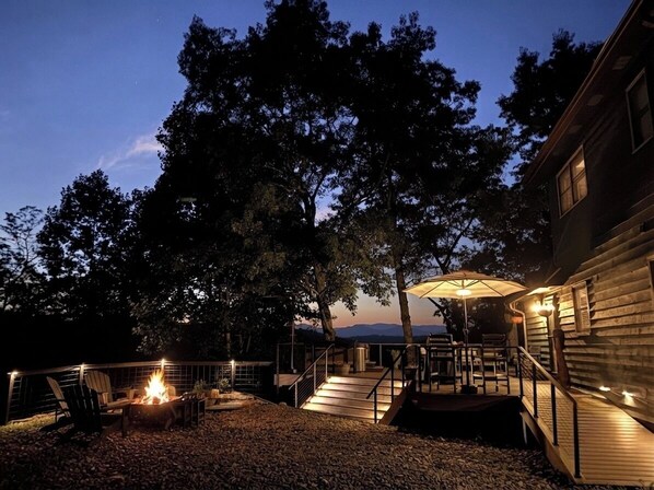 A patio area with a fire pit, outdoor furniture, and a covered seating area.