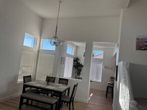 A spacious dining area with a table and chairs, large windows with blinds, and a chandelier. - Comfortable & Relaxing Gilbert Oasis with Heated Pool (Gilbert)