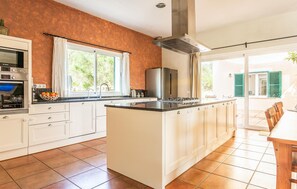 A kitchen with white cabinets, a central island, a Bosch oven, and a stainless steel refrigerator. - Stunning home in SINEU with private swimming pool, can be inside or outside (SINEU)