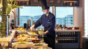 Un buffet proposant une variété de plats et une personne qui sert les clients.