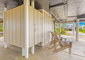 A covered outdoor area with a wooden structure, possibly a storage or utility room, and a wooden bench. - Bay-view 5BR Gulf Shores home with 5.5 baths, sleeps 12, and easy beach access. (Gulf Shores)
