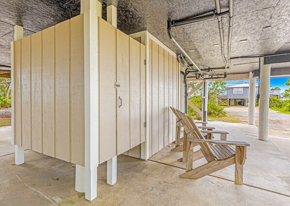 Un'area esterna coperta con struttura in legno, probabilmente un locale di stoccaggio o un ripostiglio, e una panca in legno.