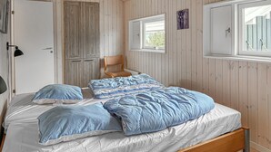 A bedroom with a wooden bed, a chair, a window, and a door. - Amazing home in Bjert with sauna (Bjert)