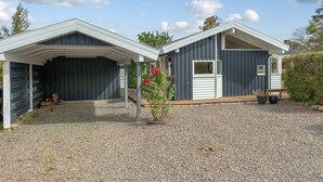 Two attached single-story buildings with a gravel driveway and a small garden area. - Amazing home in Bjert with sauna (Bjert)