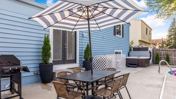 A patio with a table, chairs, a grill, and a hot tub. - Pool, Hot tub and Gameroom! (Columbus)