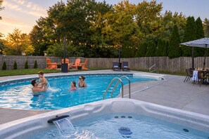 A swimming pool with a hot tub, surrounded by outdoor furniture and a wooden fence. - Pool, Hot tub and Gameroom! (Columbus)