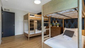 A room with two bunk beds, a wooden dresser, and a patterned wall. - Pool, Hot tub and Gameroom! (Columbus)