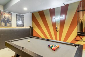 Uma mesa de bilhar com um letreiro de neon, tacos e uma bola colorida.