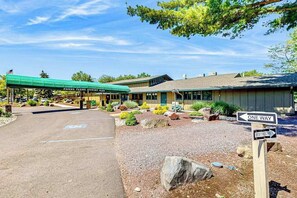 A building with a covered entrance, a sign indicating one-way traffic, and a sign for restrooms. - Pocono Home with Hot Tub, EV Charge, Pool & Tennis (Tobyhanna)