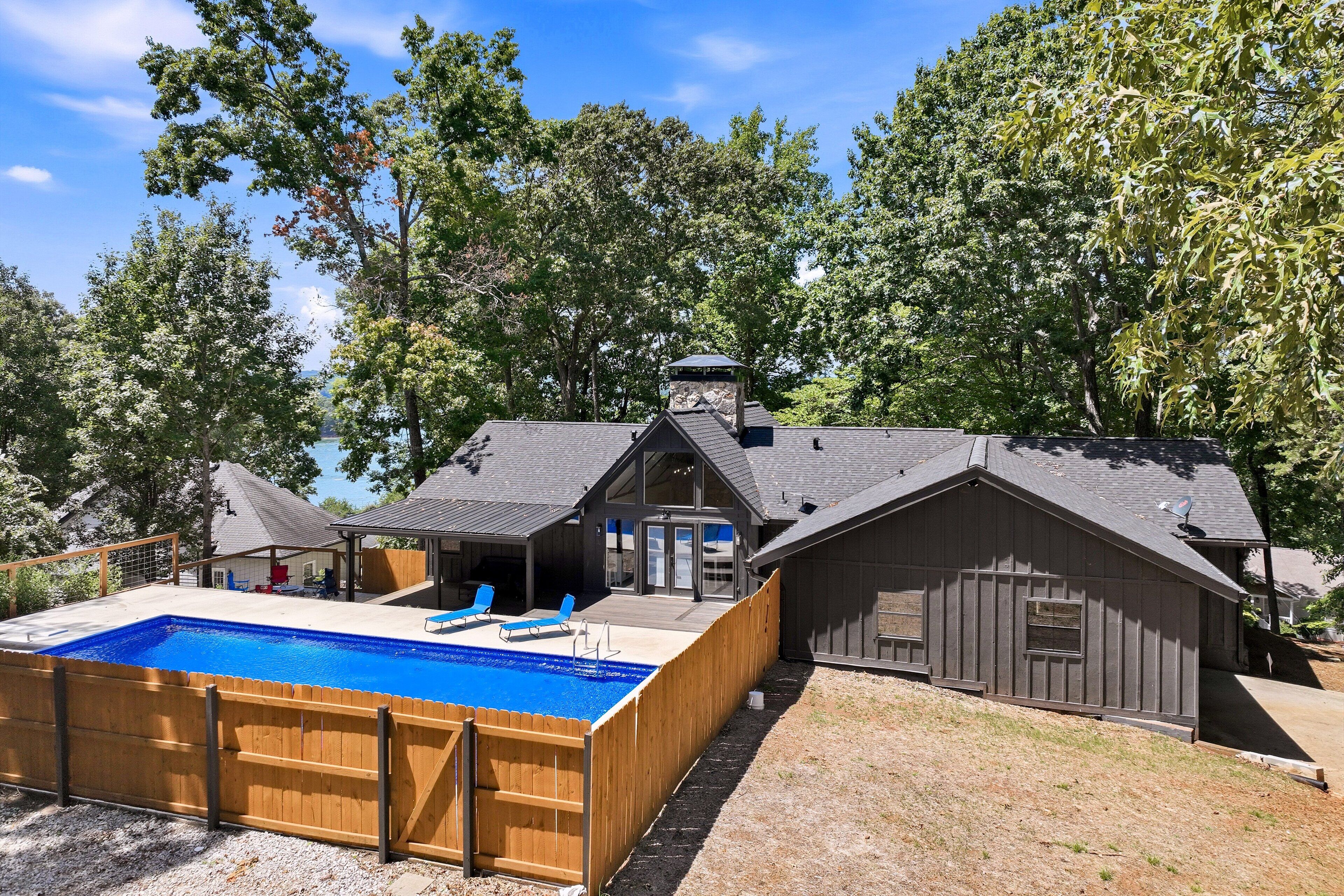 A house with a swimming pool, a covered patio, and a garage.