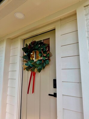A door with a wreath and a red ribbon, a keypad lock, and a small window above the door. - Inviting Gateway Near Galveston Beach for families,friends,business travelers. (La Marque)
