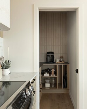 A compact kitchen with a stove, oven, and a coffee machine. - Luxury Chalet with Spa in Tremblant (Lac-Supérieur)