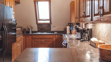 A kitchen with wooden cabinets, a stainless steel sink, and a built-in oven.