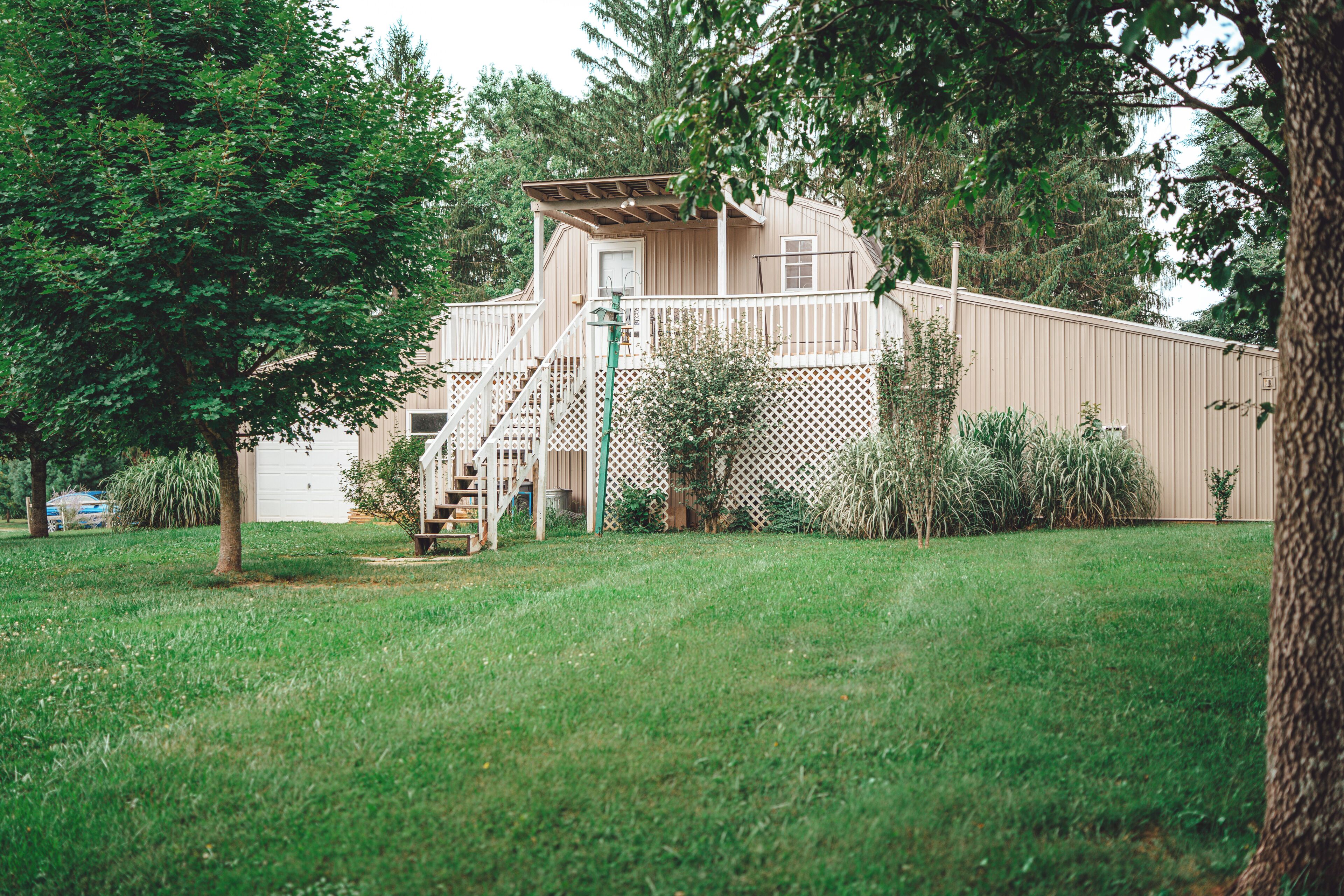 A two-story house with a wooden deck and a fenced yard.