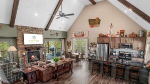 Uma sala de estar espaçosa com lareira, mesa de jantar e cozinha equipada com eletrodomésticos modernos.