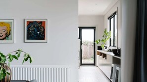 Eine moderne Küche mit weißen Schränken, einer schwarzen Arbeitsplatte und einem Fenster mit Blick auf einen Garten.