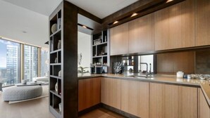 Eine moderne Küche mit Holzausstattung, einer integrierten Kochinsel und Blick auf die Stadt.