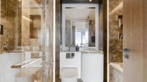 Ein modernes Badezimmer mit einer gläsernen Duschkabine, einem weißen Waschbecken und einem мраморираном Waschtisch.
