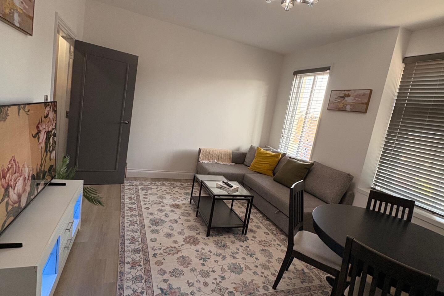 Una sala de estar con sofá, mesa de centro y mesa de comedor.