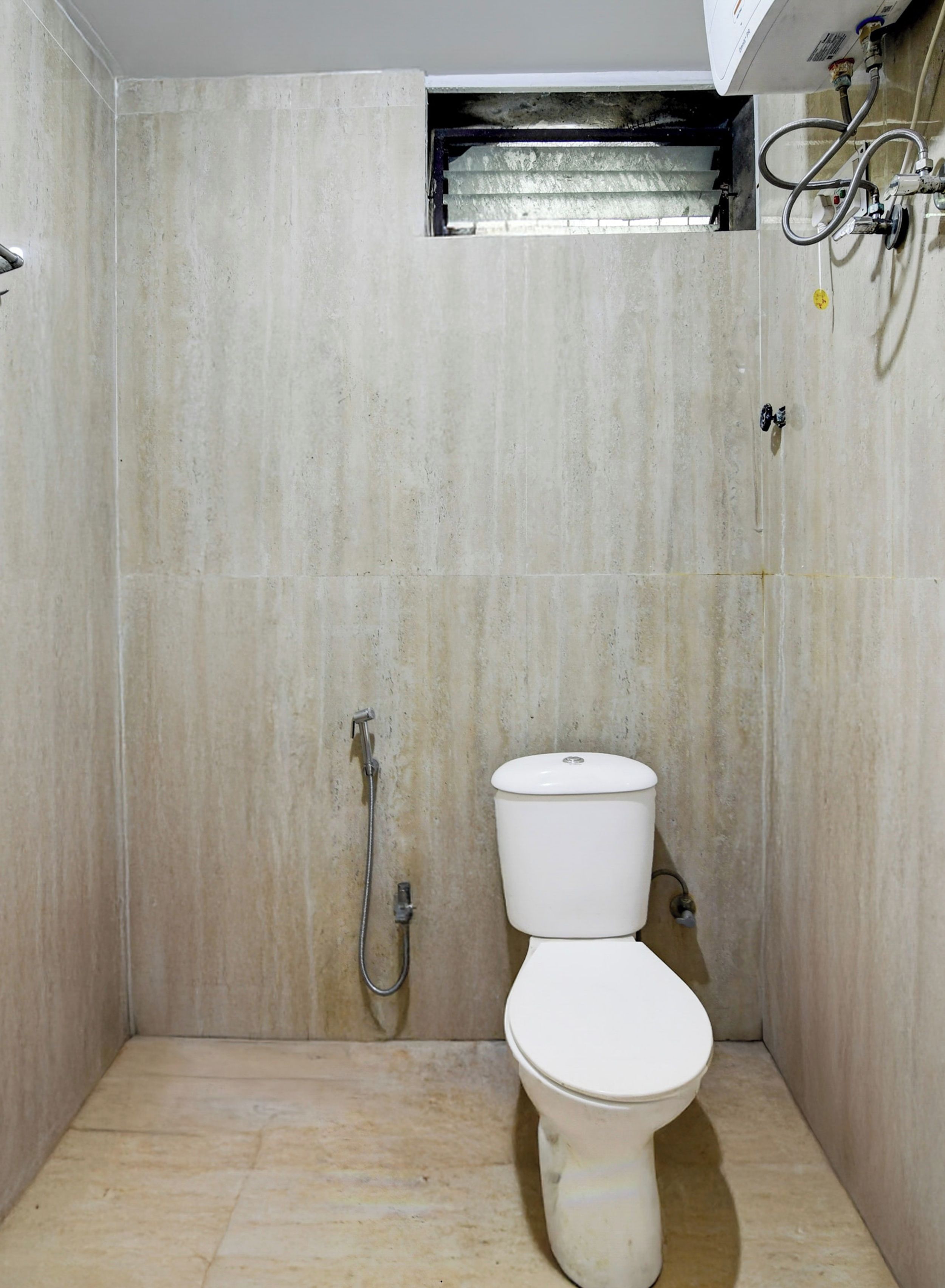 Un baño pequeño y cerrado con inodoro y ducha.