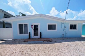 A single-story house with a front door, two windows, and a small porch area. - Luxury Waterfront Retreat located in Tavernier, FL (Tavernier)