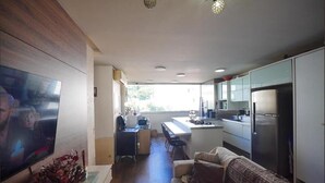 A compact living space with a kitchenette, a dining area, and a seating area with a sofa. - Fully furnished apartment near Florianópolis, pets allowed. (São José)