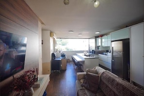 A compact living space with a kitchenette, a dining area, and a seating area with a sofa. - Fully furnished apartment near Florianópolis, pets allowed. (São José)