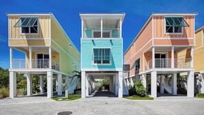 A row of three-story buildings with balconies, a central walkway, and a clear sky. - Waterfront 2BR, 2BA Islamorada retreat with pool, hot tub, and kayaks. (Islamorada)