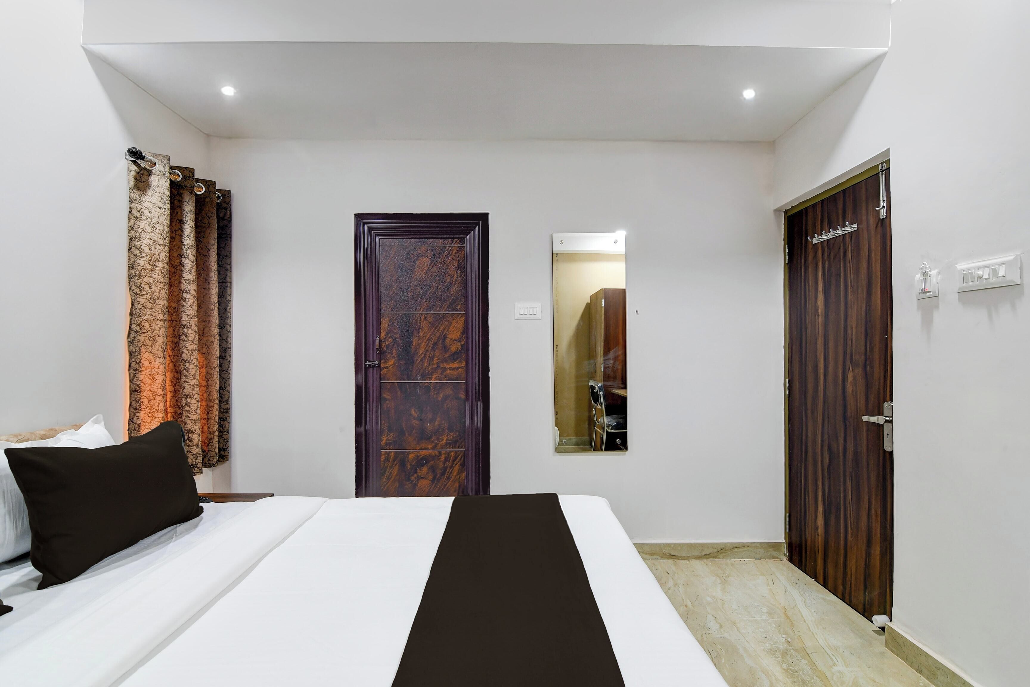 A bedroom with a bed, a wardrobe, and a mirror.