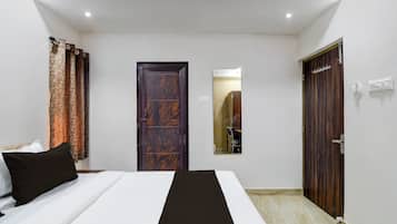 A bedroom with a bed, a wardrobe, and a mirror.