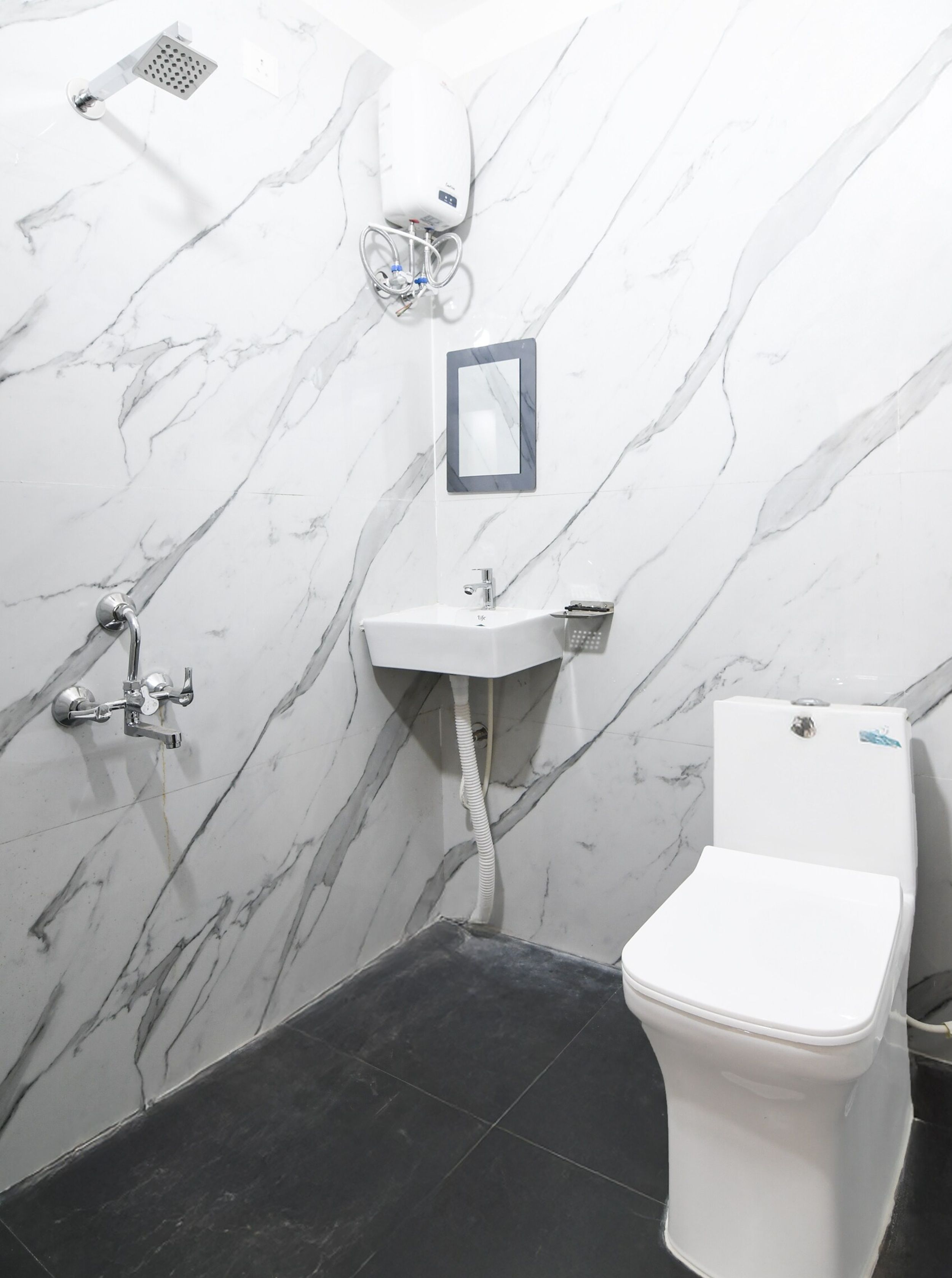 Un baño con inodoro blanco, lavabo y ducha.