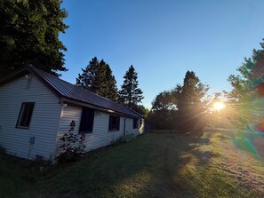 A single-story house with a sloped roof, a front door, and a small porch area. - Trail 9 Hideaway (Newberry)