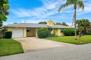 A single-story house with a garage, a well-maintained lawn, and a mailbox. - Melbourne Beach Escape: Private Pool & Pool Spa, Big Backyard, Steps to Beach (Melbourne Beach)