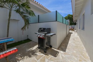 Eine Terrasse mit Grill, Tisch und Stuhl.