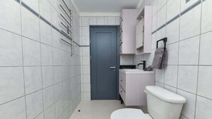 Ein kleines Badezimmer mit Toilette, Waschbecken und Schrank.