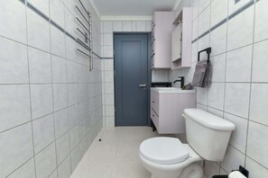 Ein kleines Badezimmer mit Toilette, Waschbecken und Schrank.